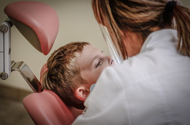 female dentist checking a child seated in chair