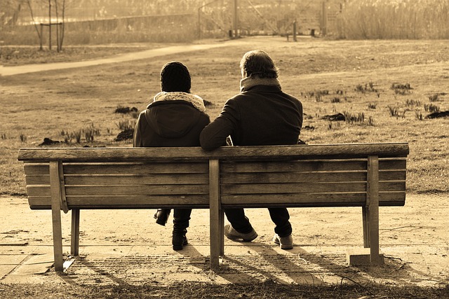 man and woman talking on a bench outside