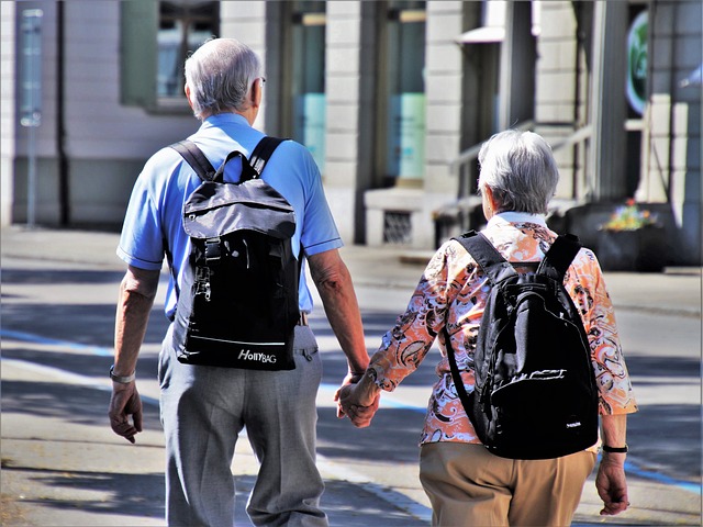 two elders with backpacks walking