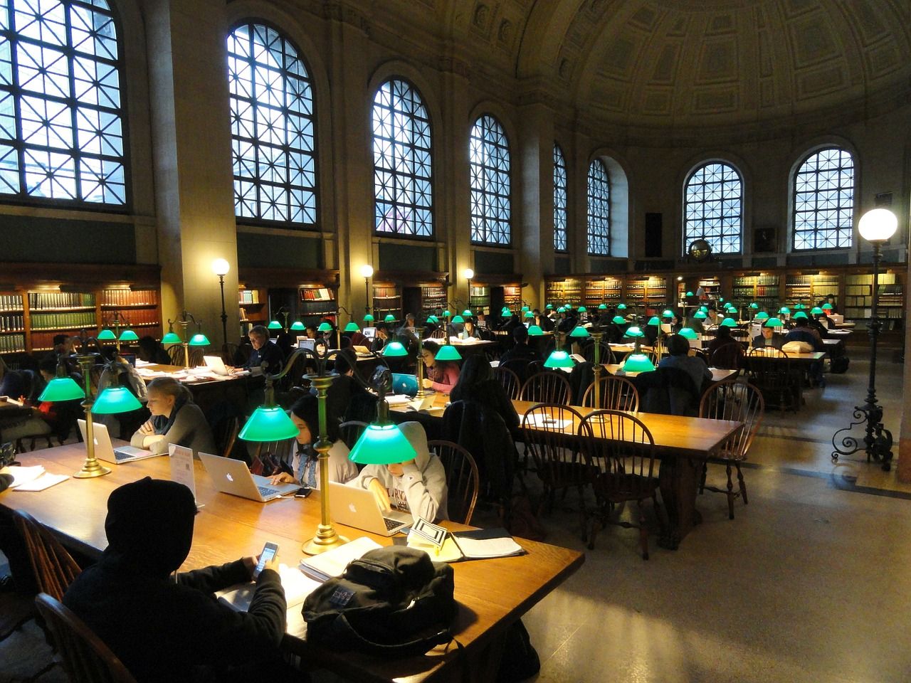 inside a large library with small lights on at each table