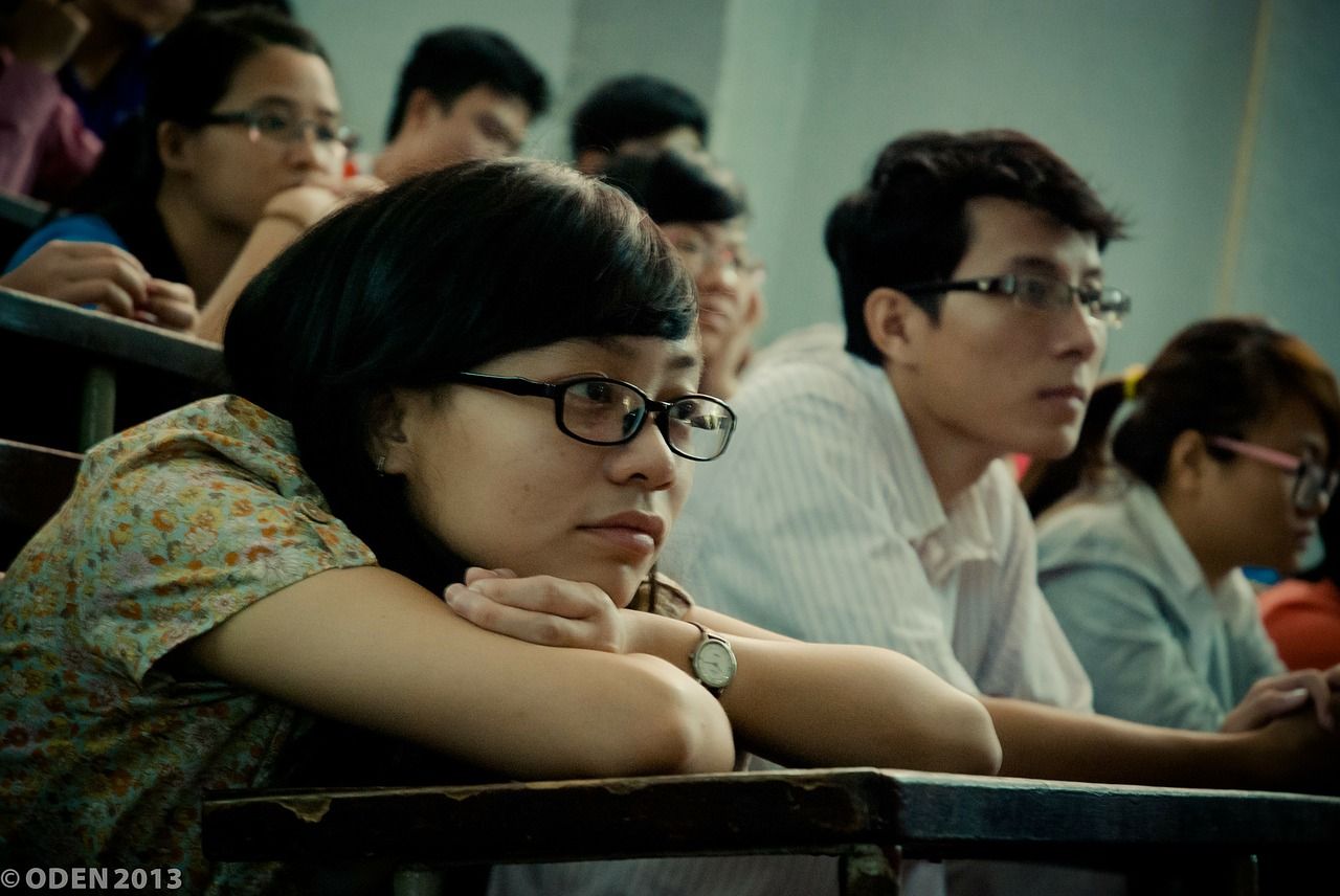 students sitting and listening in a large college lecture class