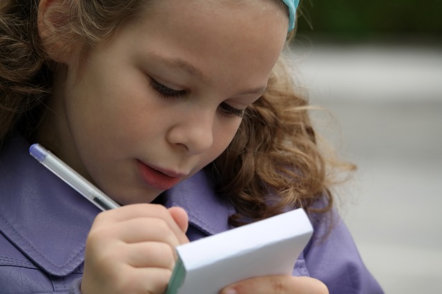 young girl student writing on a small pad