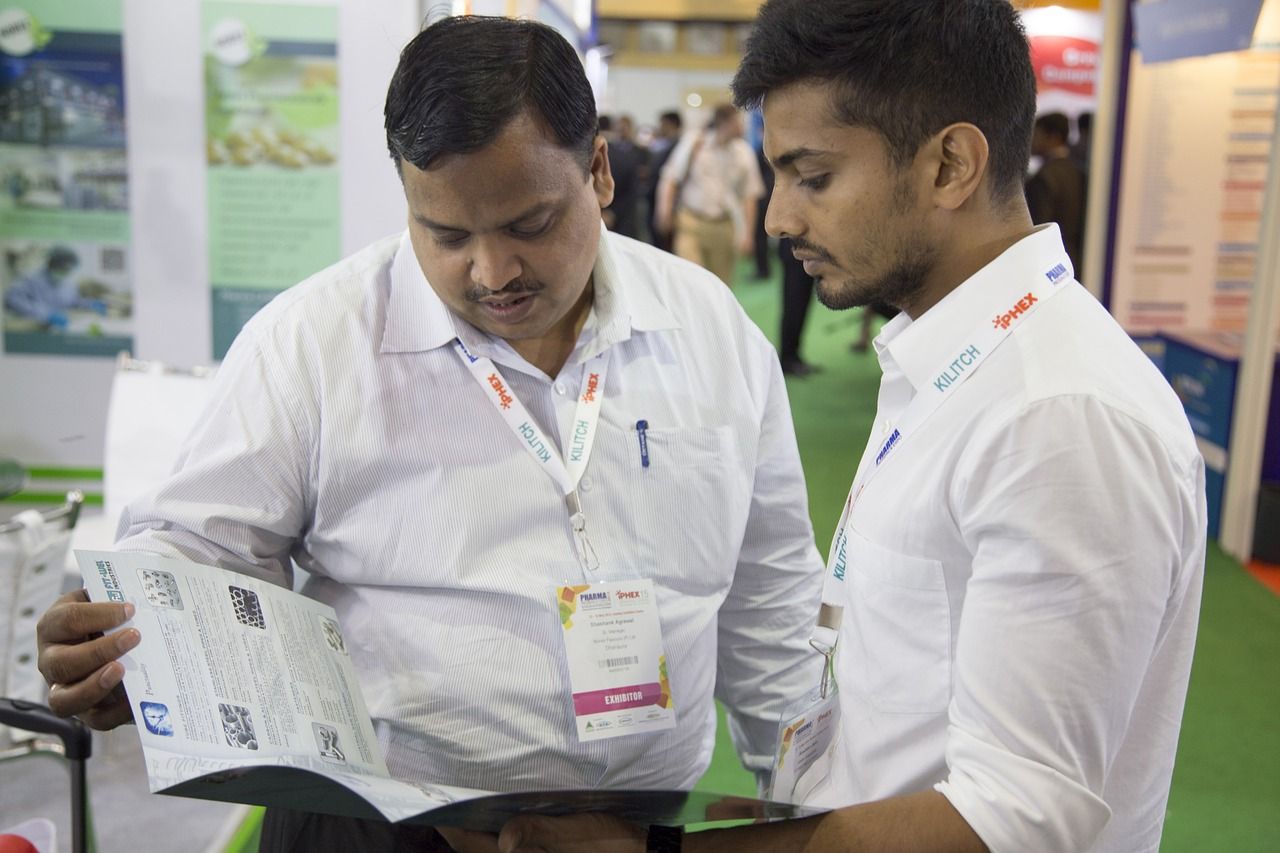 older and younger adult looking at a book and talking