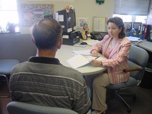 probation officer talking to man at a table