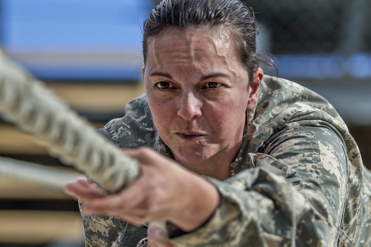 intense woman soldier doing training on rope