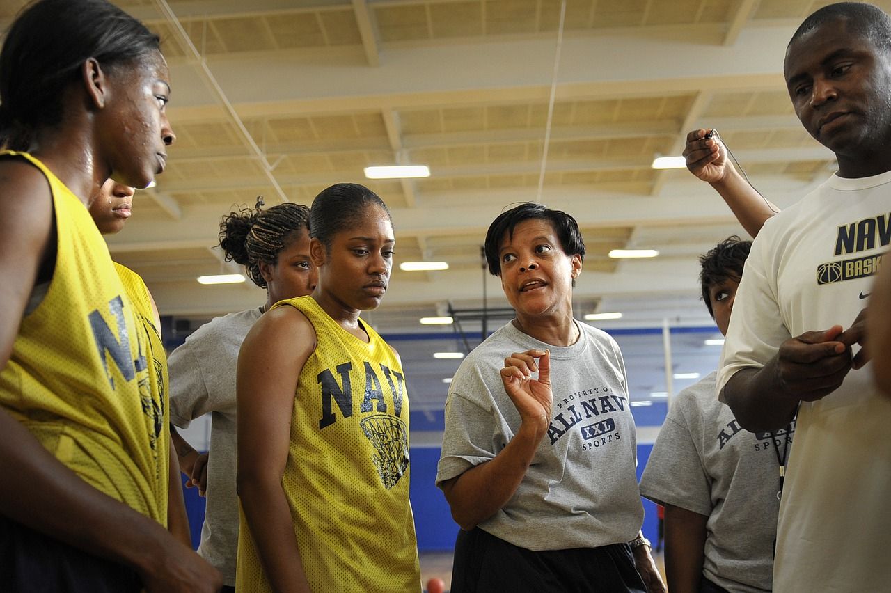 African American female coach talking to women's basketball team