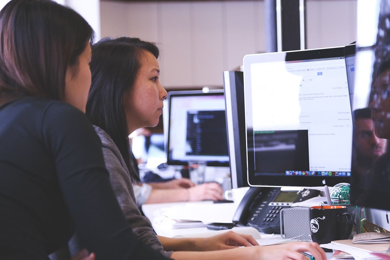 two women working at computer at a business