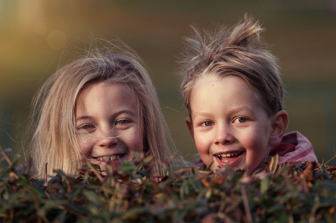 heads of one girl and one boy smiling at camera