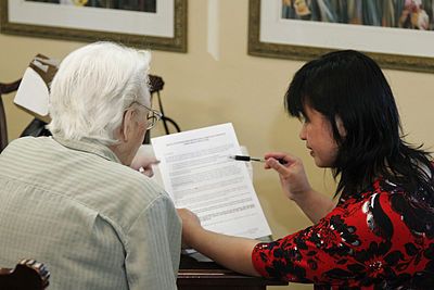 female social worker showing a paper to female elder and talking to her about it