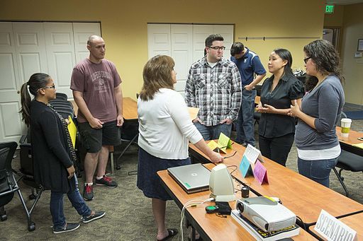 group of people talking near a computer on a table