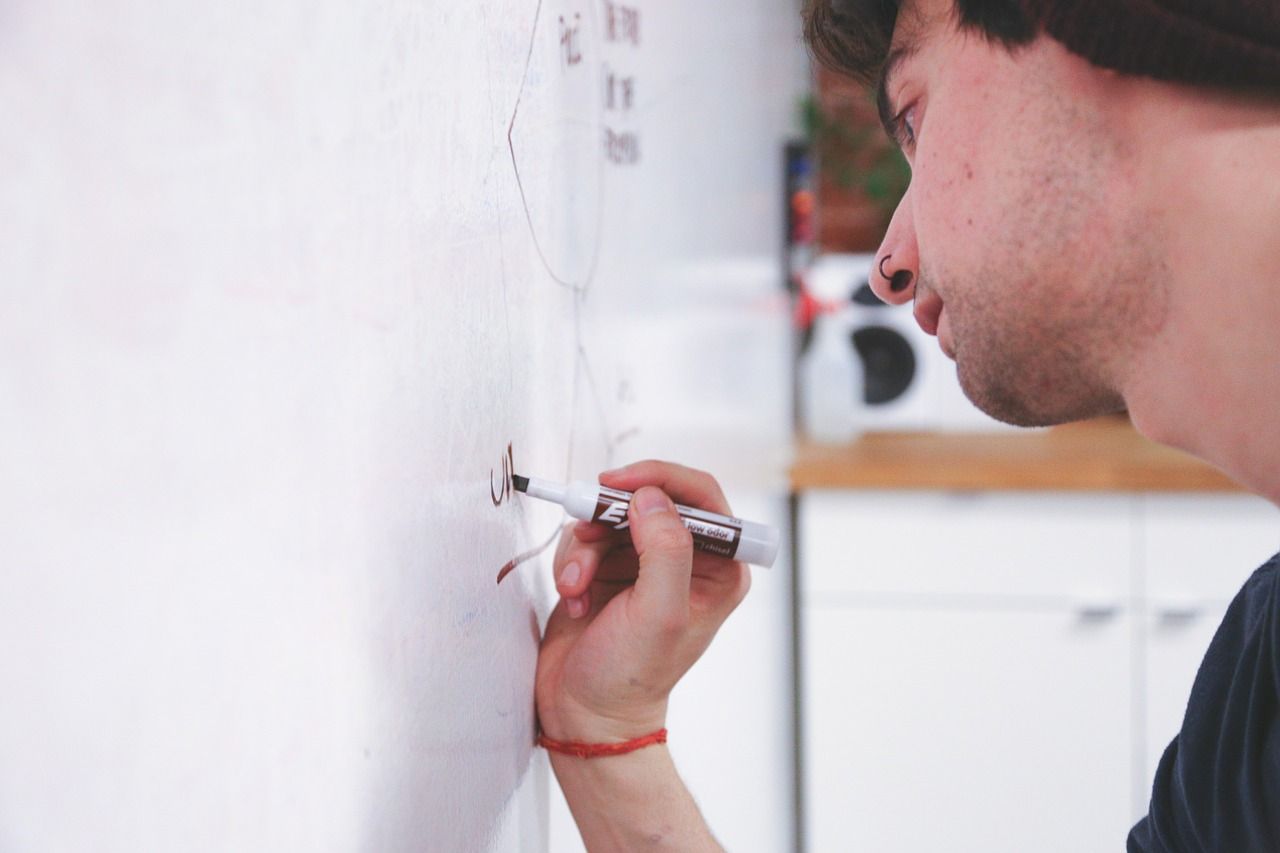 man solving a problem using a white board