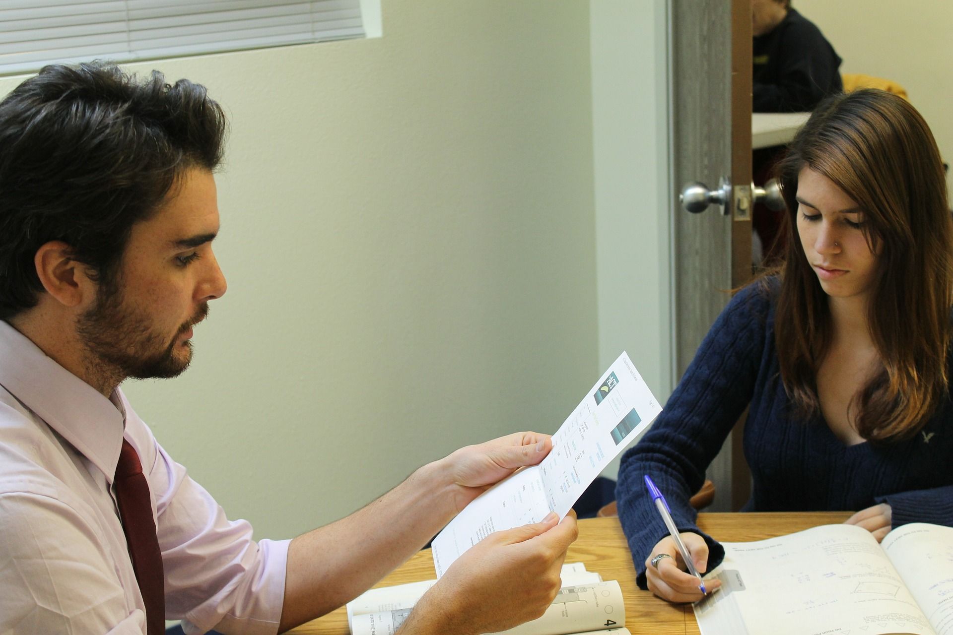 man and woman sitting at table doing work