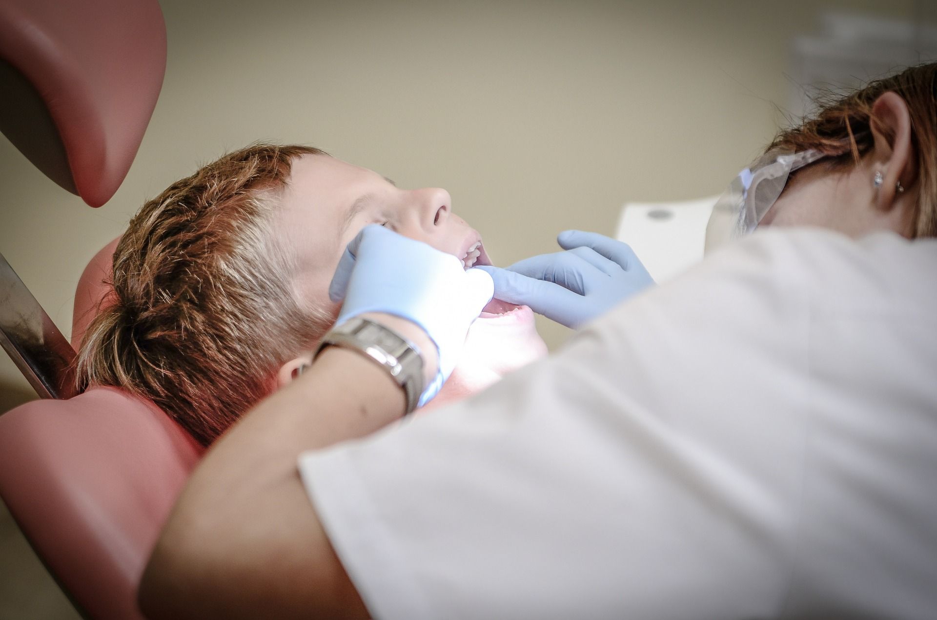 dentist working in the mouth of a little boy