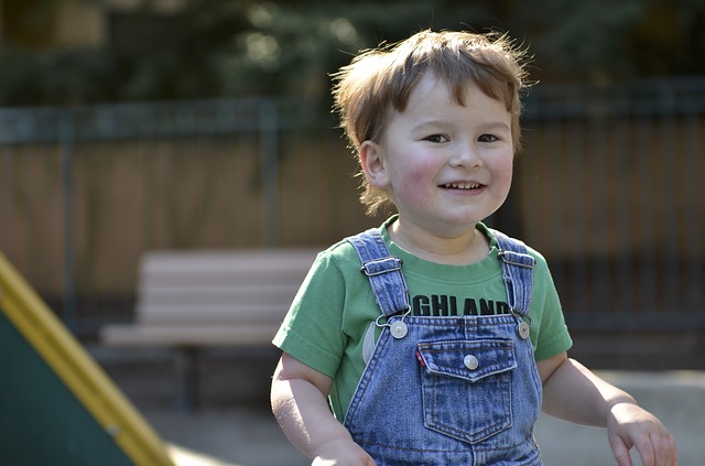 young child with autism wearing overalls