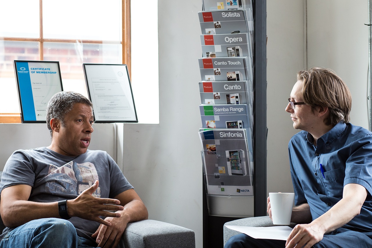 white psychologist listening to African American man talk while both are seated